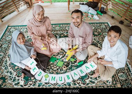 Felice padre, madre e figli che fanno bandiera catena Foto Stock