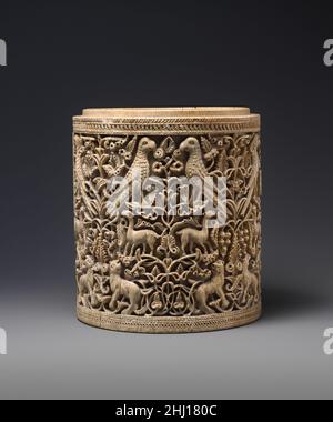 Pyxis ca. 950–75 Spagnolo questa squisitamente scolpita scatola cilindrica si ritiene sia una delle opere più compiute di un maestro del palazzo del califfo Umayyyyad ‘Abd al-Rahman III (r. 912–61), che governava la maggior parte della penisola iberica. A giudicare da altri esempi, il coperchio a cupola mancante di questa scatola probabilmente aveva un’iscrizione che indicava il nome del proprietario e la data. I pixidi islamici, noti come ushnan in arabo, erano esclusivamente secolari e venivano usati per conservare gioielli e cosmetici. L'incorporazione di uccelli, leoni e gazzelle in mezzo riccamente scolpiti rotoli di vite è tipico di densa Isla simmetrica Foto Stock