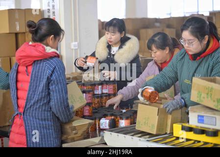 (220126) -- LUZHOU, 26 gennaio 2022 (Xinhua) -- Wu Qiuyue (2nd L) impacchi di rafano secco con operai nel villaggio di Zhuhai nella città di Baijie del distretto di Naxi, Luzhou, provincia sudoccidentale della Cina di Sichuan, 18 gennaio 2022. Anni fa, Wu Qiuyue lavorava in una fabbrica di elettronica a Shenzhen nella Cina meridionale. Più tardi, per prendersi cura dei suoi genitori e della sua figlia, lei e suo marito Huang Zhongping hanno deciso di tornare nella sua città natale per avviare un'impresa insieme. All'inizio del 2020, la coppia, con una certa esperienza nel commercio elettronico, ha cominciato a provare il video short shooting ed ha aperto un cliente sul corto Foto Stock