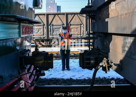 (220126) -- TAIYUAN, 26 gennaio 2022 (Xinhua) -- li Taihong utilizza bandiere di segnalazione per dirigere il treno a Taiyuan, provincia cinese settentrionale dello Shanxi, il 25 gennaio 2022 li Taihong, 54, E suo figlio li KE sono entrambi i macchinisti della China Railway Taiyuan Bureau Group Co., Ltd. Lavorando in diverse posizioni, trascorrono più tempo a parte che insieme, soprattutto durante la corsa di viaggio del Festival di primavera. Li Ke è orgogliosa di parlare della sua tradizione familiare di lavorare nel sistema ferroviario. "Mio padre è sempre stato il mio modello di ruolo. Continuerò il suo impegno per tutta la vita nel settore ferroviario", ha affermato. (Xinhua/Cao Foto Stock