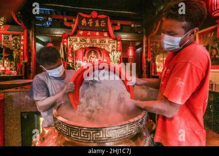 Bogor, Indonesia. 26th Jan 2022. I lavoratori sollevano le ceneri durante il rituale di cenere in arrivo del nuovo anno lunare al tempio di Dhanagun a Bogor, Giava occidentale, Indonesia il 26 gennaio 2022. Il rituale di setacciatura delle ceneri è un'attività per pulire le ceneri dell'incenso in un bruciatore di incenso chiamato Heyoloh che è fatto soltanto una volta all'anno. (Foto di Andi M Ridwan/INA Photo Agency/Sipa USA) Credit: Sipa USA/Alamy Live News Foto Stock