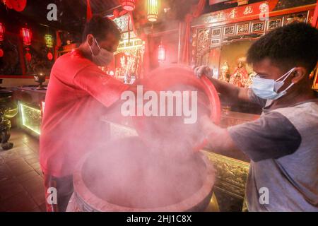 Bogor, Indonesia. 26th Jan 2022. I lavoratori sollevano le ceneri durante il rituale di cenere in arrivo del nuovo anno lunare al tempio di Dhanagun a Bogor, Giava occidentale, Indonesia il 26 gennaio 2022. Il rituale di setacciatura delle ceneri è un'attività per pulire le ceneri dell'incenso in un bruciatore di incenso chiamato Heyoloh che è fatto soltanto una volta all'anno. (Foto di Andi M Ridwan/INA Photo Agency/Sipa USA) Credit: Sipa USA/Alamy Live News Foto Stock