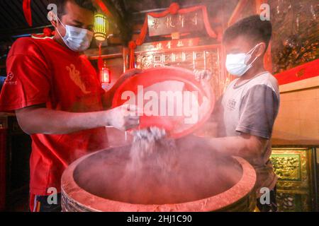 Bogor, Indonesia. 26th Jan 2022. I lavoratori sollevano le ceneri durante il rituale di cenere in arrivo del nuovo anno lunare al tempio di Dhanagun a Bogor, Giava occidentale, Indonesia il 26 gennaio 2022. Il rituale di setacciatura delle ceneri è un'attività per pulire le ceneri dell'incenso in un bruciatore di incenso chiamato Heyoloh che è fatto soltanto una volta all'anno. (Foto di Andi M Ridwan/INA Photo Agency/Sipa USA) Credit: Sipa USA/Alamy Live News Foto Stock