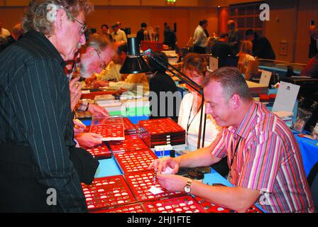 Un commerciante & compratore di moneta discutono le monete d'oro antiche, al Coinex della British Numismatic Trade Association, esposizione/evento del numismist del collettore di moneta 2007 Foto Stock