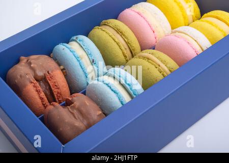 Macaroon esclusivi in scatola blu isolato sul bianco Foto Stock