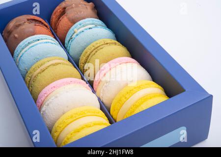 Macaroon esclusivi in scatola blu isolato sul bianco Foto Stock