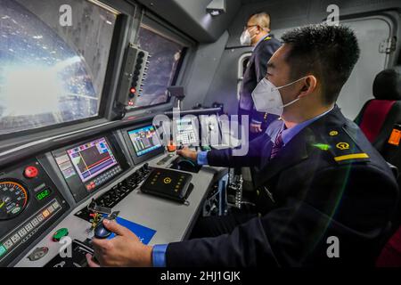 (220126) -- TAIYUAN, 26 gennaio 2022 (Xinhua) -- li Ke (R) lavora alla cabina di guida di un treno a Taiyuan, nella provincia di Shanxi della Cina settentrionale, il 25 gennaio 2022. Li Taihong, 54, e suo figlio li KE sono entrambi i macchinisti del China Railway Taiyuan Bureau Group Co., Ltd. Lavorando in diverse posizioni, trascorrono più tempo a parte che insieme, soprattutto durante la corsa di viaggio del Festival di Primavera. Li Ke è orgogliosa di parlare della sua tradizione familiare di lavorare nel sistema ferroviario. "Mio padre è sempre stato il mio modello di ruolo. Continuerò il suo impegno per tutta la vita nel settore ferroviario", ha affermato. (Xinhua/Cao Foto Stock