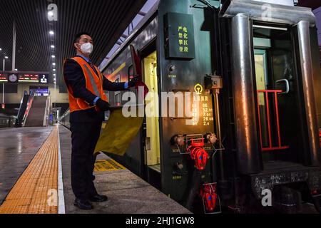 (220126) -- TAIYUAN, 26 gennaio 2022 (Xinhua) -- li KE utilizza bandiere di segnalazione per dirigere il treno a Taiyuan, provincia di Shanxi nella Cina settentrionale, il 25 gennaio 2022. Li Taihong, 54, e suo figlio li KE sono entrambi i macchinisti del China Railway Taiyuan Bureau Group Co., Ltd. Lavorando in diverse posizioni, trascorrono più tempo a parte che insieme, soprattutto durante la corsa di viaggio del Festival di Primavera. Li Ke è orgogliosa di parlare della sua tradizione familiare di lavorare nel sistema ferroviario. "Mio padre è sempre stato il mio modello di ruolo. Continuerò il suo impegno per tutta la vita nel settore ferroviario", ha affermato. (Xinhua/Cao Yang Foto Stock