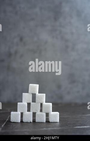 Piramide di cubetti di zucchero su sfondo grigio Foto Stock