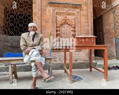 Haji Abul Anwar, è la guardia volontaria, più pulito e generale custode della moschea di Bagha, Rajshahi, Bangladesh. La moschea fu costruita nel 1523-1524 (930 AH) dal sultano Nusrat Shah, figlio di Alauddin Shah, il fondatore della dinastia Husain Shahi. Più tardi, la moschea fu rinnovata in tempi diversi e quando le cupole della moschea crollarono, la moschea distrutta fu ricostruita nel 1897. Bangladesh. Foto Stock