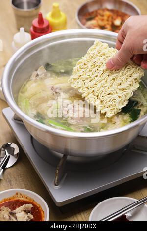 Hot pot per zuppa di pollo intera coreana, spaghetti istantanei alla fine del pasto. Foto Stock