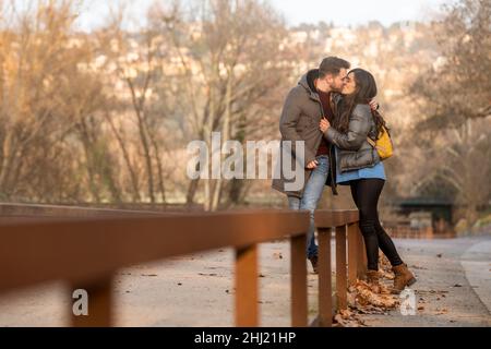 Giovane coppia eterosessuale bacia in un parco il giorno di San Valentino Foto Stock