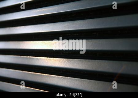 La ruggine di una vecchia griglia metallica con i riflessi del sole in una zona abbandonata Foto Stock