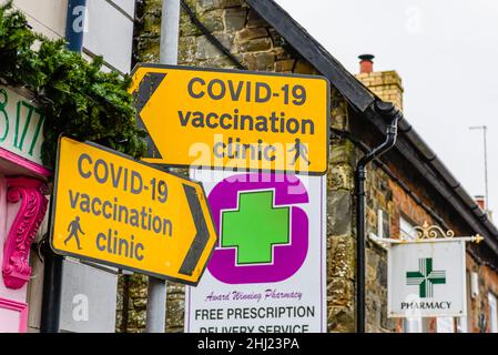 Segni gialli per un ambulatorio di vaccinazione COVID-19 presso una farmacia locale. Foto Stock