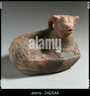 Aschi di terracotta sotto forma di cane 2nd–1st secolo a.C. greco inscritto 'EUPLOUS' questo aschi sotto forma di cane reclinabile è collegato alle fiasche di Magenta Ware esposte nelle vicinanze (06.1021.265, 07.286.131). La sua classificazione come esempio di ceramica di Magenta Ware, tuttavia, è impedita dalla mancanza di tracce del pigmento rosso profondo, che normalmente caratterizza la tecnica. Il nome inscritto sulla base degli askos è attestato in iscrizioni da Boeotia nella Grecia centrale, e forse può puntare al luogo della sua fabbricazione.. Asche di terracotta a forma di cane 256597 Foto Stock