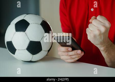 Primo piano del giovane felice festeggia la vittoria della sua scommessa sportiva. Concetto di scommesse, gioco d'azzardo. Foto Stock