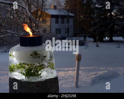 Una candela di giardino all'aperto a prova di vento illuminata nel cortile a Natale Foto Stock