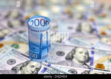 Rubli russi su sfondo di dollari americani. Concetto di tasso di cambio, sanzioni, crollo del rublo Foto Stock