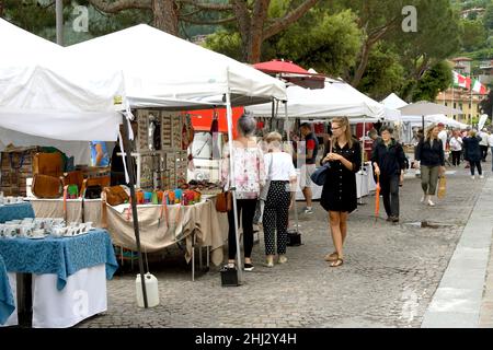 Menaggio, Lago di Como, Italia - Giugno 2019: Persone che attraversano un mercato nel comune di Menaggio sul Lago di Como. Foto Stock