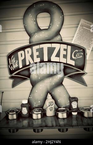 Grafica gigante Pretzel per la Key West Pretzel Company a Key West, Florida, USA. Parete giallo brillante e grafica verde sul muro sopra ketchup Foto Stock