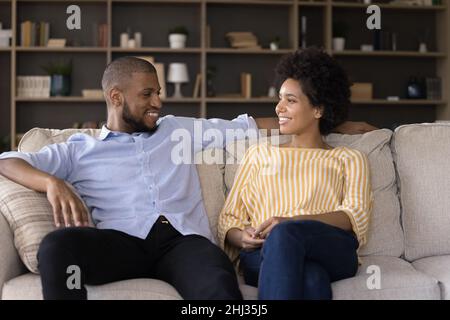 Coppia africana che ha conversazione seduto sul divano a casa Foto Stock
