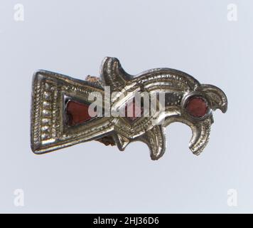 Uccello-a forma di Brooch fine 6th secolo Frankish l'abito delle donne francoche consisteva generalmente di una tunica, cinched da una cinghia da cui appeso una serie di pendenti. Un involucro o un mantello passò sopra la tunica. Scarpe e calze, allacciate con fibbie, copriva le gambe. Orecchini, collane e pettini completarono l'ensemble.Apares di questo abito cambiato dal 300s al 600s, e le spille in particolare trasportano cambiamenti di gusto. Dal 300s al 500s, coppie di piccole spille, in una serie di forme inventive, tenevano l'involucro in posizione. Entro il 600s, un unico grande disco spilla, di solito decorare elaborato Foto Stock