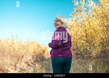 Bella donna sportiva matura mantenersi in forma con lo sport in natura. Persone sportive attive Foto Stock