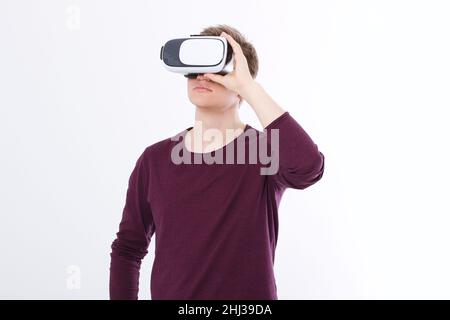 Giovane uomo che indossa occhiali per realtà virtuale isolati su sfondo bianco. Copia lo spazio e riponi. Smartphone e visore VR. Immagine orizzontale Foto Stock