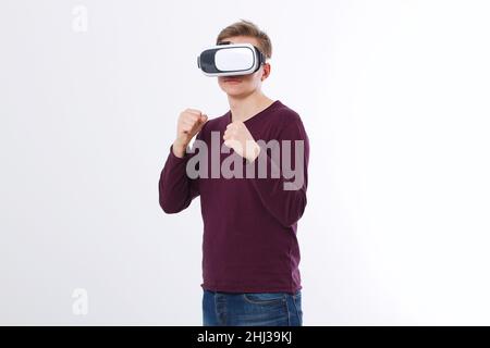 Giovane un indossare occhiali di realtà virtuale isolato su sfondo bianco. Visore con tecnologia VR Glasses e gioco di pugilato. Copia lo spazio e riponi Foto Stock
