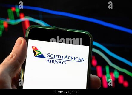 Cina. 04th Dic 2021. In questa illustrazione della foto, il logo della compagnia aerea South African Airways è visualizzato su uno smartphone con un grafico dell'indice delle borse economiche sullo sfondo. (Foto di Budrul Chukrut/SOPA Images/Sipa USA) Credit: Sipa USA/Alamy Live News Foto Stock