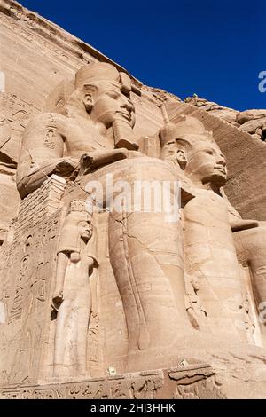 Colossi di Rameses II e Nefertari nella facciata del Grande Tempio di Ramesses II, Abu Simbel, Egitto Foto Stock