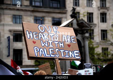 Palastine Placard tenuto a una protesta a Manchester con i nostri cuori sono con la Palestina scritto sul fronte Foto Stock