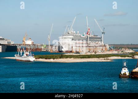 La nave da crociera è circondata da gru in piedi in un molo asciutto a Freeport sull'isola di Grand Bahama. Foto Stock