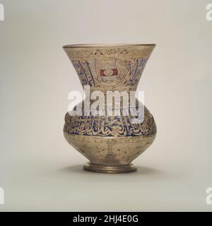 Moschea lampada di Amir Ahmad al-Mihmandar ca. 1325 secondo la sua iscrizione, Ahmad al-Mihmandar (d. 1332) donò questa lampada, probabilmente una delle tante, alla madrasa che eresse al Cairo nel 1324-25. Il suo blazon, un disco bianco caricato con uno scudo d'oro contro una barra rossa, appare sei volte, in mezzo ad un'iscrizione Coranica sul collo (Sura 9:18) e contro densi fogliame sul lato inferiore. Ascolta gli esperti che illuminano la storia di questa opera d'arte Ascolta Riproduci o pausa #6699. Lampade a moschea, parte 1 riproduzione o pausa #6748. Lampade a moschea, parte 2 riproduzione o pausa #1164. Bambini: Lampade moschea supportate da Bloomberg Philanth Foto Stock