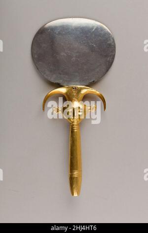 Specchio con manico a forma di emblema Hathor ca. 1479–1425 a.C. nuovo regno l'impugnatura di questo specchio era in origine in legno (ora restaurato) ricoperto di lamina d'oro. Il volto della donna con le orecchie di mucca rappresenta la dea Bat ed è anche un emblema della dea Hathor. L'uso dell'oro e dell'argento, piuttosto che del legno e del bronzo, lo identifica come il possesso di un membro dell'élite, in questo caso una delle tre mogli straniere di Thutmose III La cartouche del re è inscritta sopra il volto.. Specchio con manico in forma di emblema Hathor. CA. 1479–1425 A.C. Disco: Argento; manico: woo Foto Stock