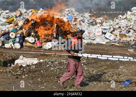 Lahore, Pakistan. 26th Jan 2022. I funzionari doganali pakistani bruciano per distruggere le merci contrabbandiate (sigarette, tabacco da masticare, noci di Betel, fuochi d'artificio e altre cose vicino al confine di Wagha alla vigilia della giornata doganale mondiale a Lahore. Un mattone di droga confiscata, sigarette e altri beni che sono stati sequestrati da diverse aree, durante la cerimonia di lancio di campagne di sensibilizzazione in tutta la provincia, organizzato dalla dogana pakistana tenuto al confine di Wagha a Lahore (Foto di Rana Sajid Hussain/Pacific Press) Credit: Pacific Press Media Production Corp./Alamy Live News Foto Stock