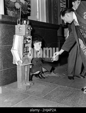 Un ragazzo giovane con un ragazzo robot. 8th ottobre 1957. Foto Stock