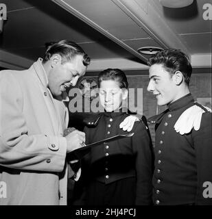 Bill Haley durante la sua prima visita in Inghilterra, che è stato in gran parte sponsorizzato dal Daily Mirror. Bill firma autografi per il personale a Waterloo. 5th febbraio 1957. Foto Stock