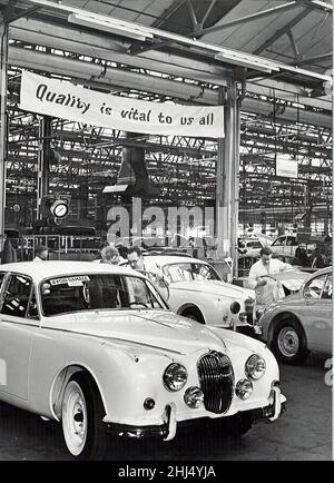 Fabbrica Jaguar Cars, Browns Lane, Coventry. Il banner sopra la pista recita: 'La qualità è vitale per noi all'11th gennaio 1961 Foto Stock