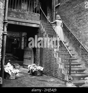 Modello posato fotografia di donna che entra in una chirurgia della Slum, Back Street aborto Clinic, Londra, 17th gennaio 1958. Pubblicato nel Women's Sunday Mirror 19th gennaio 1958. Foto Stock