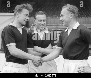 Il capitano inglese Billy Wright (a destra) scrolla le mani con la nuova recluta Bobby Charlton del Manchester United guardata da Jim Langley mentre il lato nazionale si prepara per la partita contro la Scozia al parco di Hampden con una sessione di addestramento a Maine Road.16th Aprile 1958. Foto Stock