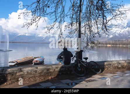 Srinagar, India. 26th Jan 2022. Un uomo si siede sulle rive del lago dal durante una giornata invernale di sole a Srinagar. (Foto di Idrees Abbas/SOPA Images/Sipa USA) Credit: Sipa USA/Alamy Live News Foto Stock