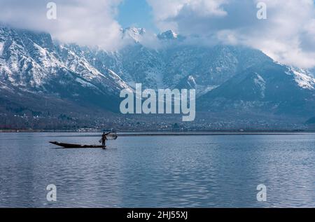 Srinagar, India. 26th Jan 2022. Un pescatore lancia una rete di pesca nel lago dal durante una giornata invernale di sole a Srinagar. (Foto di Idrees Abbas/SOPA Images/Sipa USA) Credit: Sipa USA/Alamy Live News Foto Stock