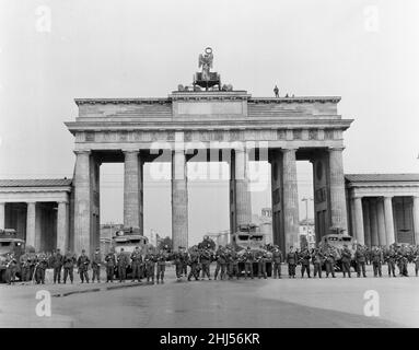 Inizio della costruzione del Muro di Berlino.a mezzanotte il 13th agosto la polizia e le unità dell'esercito tedesco orientale iniziarono a chiudere il confine e, entro domenica mattina, il 13 agosto, il confine con Berlino Ovest fu chiuso. La foto scattata tre giorni dopo mostra: I compagni dei gruppi di combattimento della classe operaia, impiegati per proteggere il confine, si trovano pronti presso la porta di Brandeburgo, protetta da un veicolo armato scout della polizia di frontiera. Il sito è stato visitato dal sindaco di Berlino Ovest Willy Brandt e dai generali dell'esercito americano. 16th agosto 1961. Foto Stock