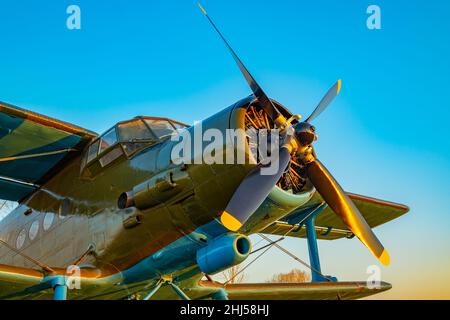 pale di elica del motore di un vecchio velivolo con parte della fusoliera, cabina e ali in colore verde kaki Foto Stock