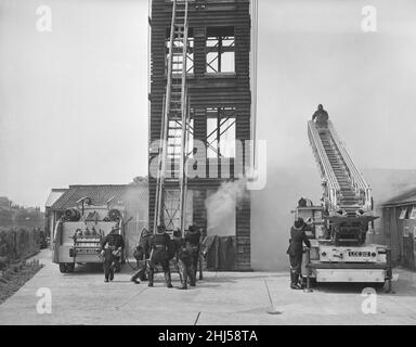 Cambridge Fire Service intraprende un salvataggio da una torre di pratica di fumo registrato durante l'ispezione annuale di tutte le stazioni di fuoco nella contea da parte del capo vigili del fuoco. Maggio 1959 Foto Stock