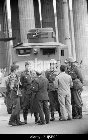 Inizio della costruzione del muro di Berlino. A mezzanotte del 13th agosto la polizia e le unità dell'esercito della Germania orientale cominciarono a chiudere il confine e, entro la domenica mattina del 13 agosto, il confine con Berlino Ovest fu chiuso. Foto scattata tre giorni dopo mostra: Polizia di frontiera della Germania Est e guardie alla porta di Brandeburgo durante una visita al punto di riferimento dal sindaco di Berlino Ovest Willy Brandt e l'esercito americano generali. 16th agosto 1961. Foto Stock