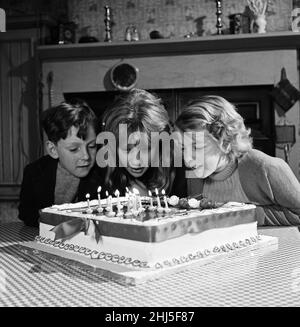 La star del cinema Hayley Mills festeggia il suo 15th compleanno presso i Pinewood Studios dove sta filmando "Whistle Down the Wind". Lo studio ha presentato Hayley con una torta, che ha condiviso con il resto del cast. È raffigurata soffiare fuori le candele con Alan Barnes (7 anni, a sinistra) e Diane Holgate (10 anni).18th Aprile 1961. Foto Stock