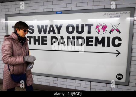 Londra, Regno Unito. 26th Jan 2022. Una donna che indossa una maschera passa accanto a un segno che promuove le vaccinazioni alla stazione di Westminster a London.dal 27th gennaio, l'uso della maschera facciale in tutti i luoghi pubblici cesserà di essere obbligatorio come la minaccia posta dalla variante Omicron di Covid-19 sides. Credit: SOPA Images Limited/Alamy Live News Foto Stock