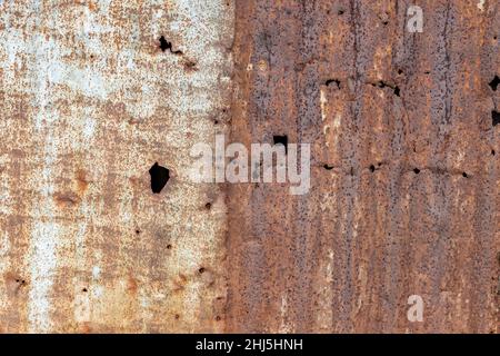Rustic textured rotto vecchio foglio di metallo ondulato con fori per lo sfondo Foto Stock